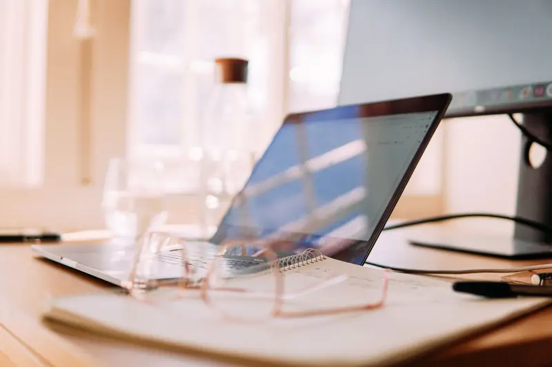 Opgeruimde werkplek met laptop en extra beeldscherm in natuurlijk licht